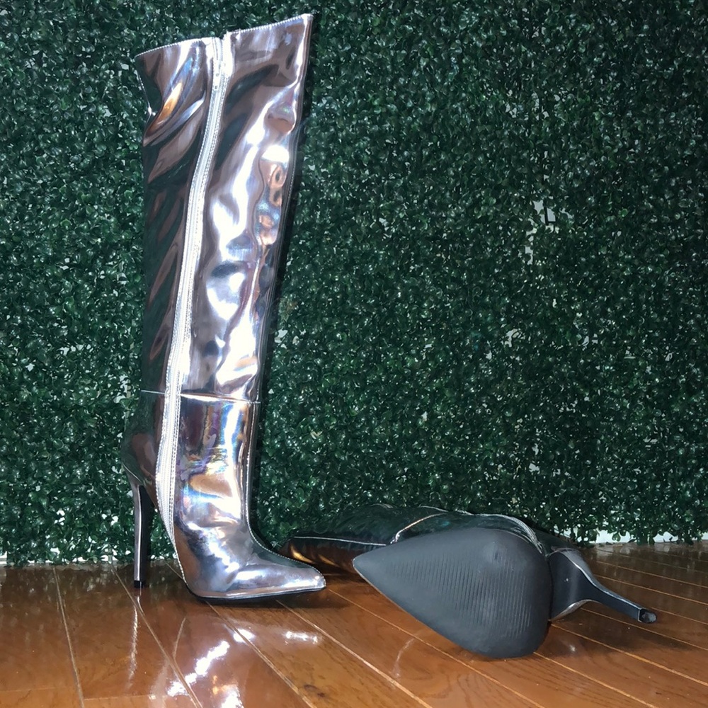 Shiny silver knee high heeled boots.